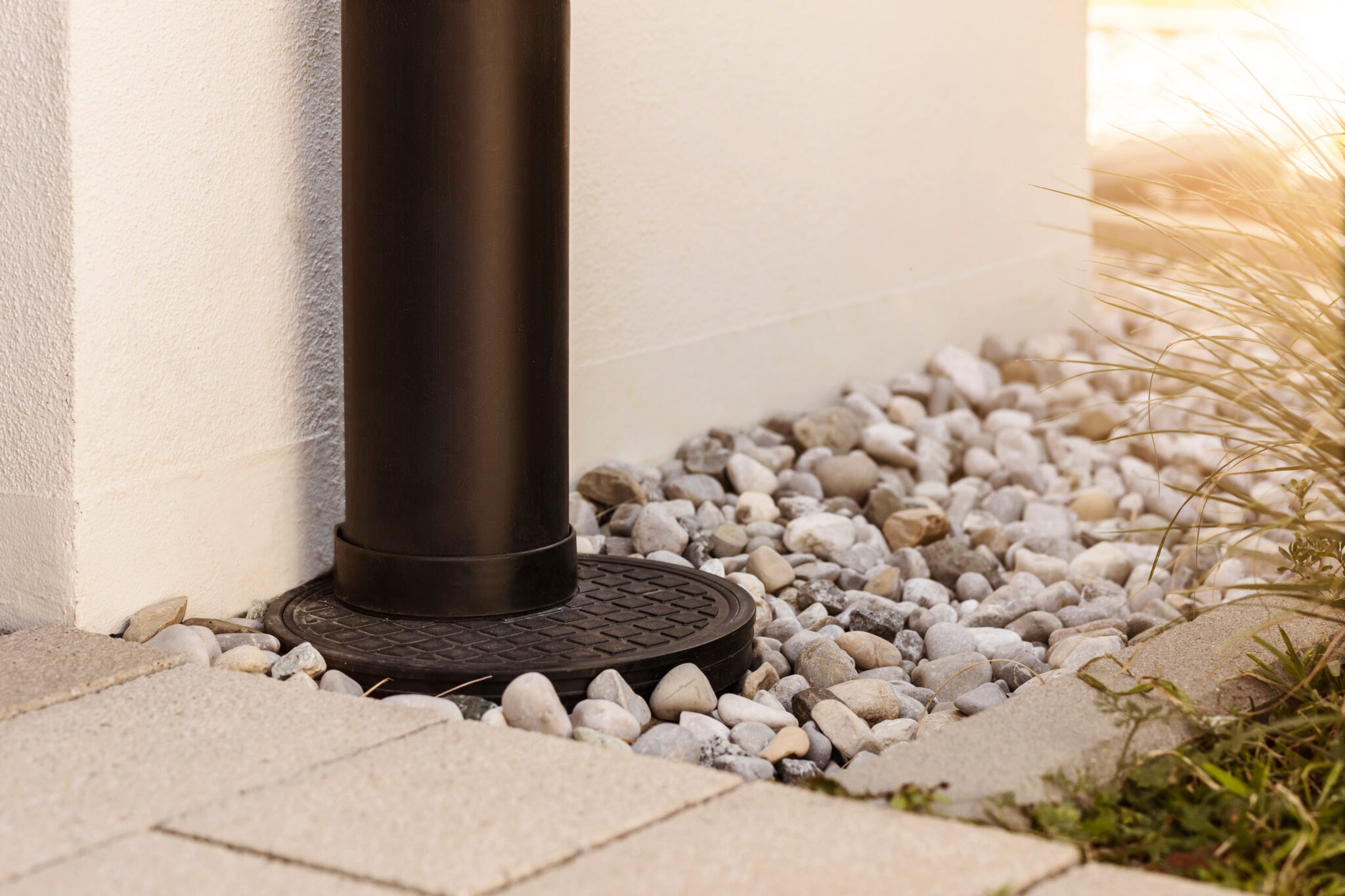 French drain Water Drainage pipe with water Stones Gravel aroud House