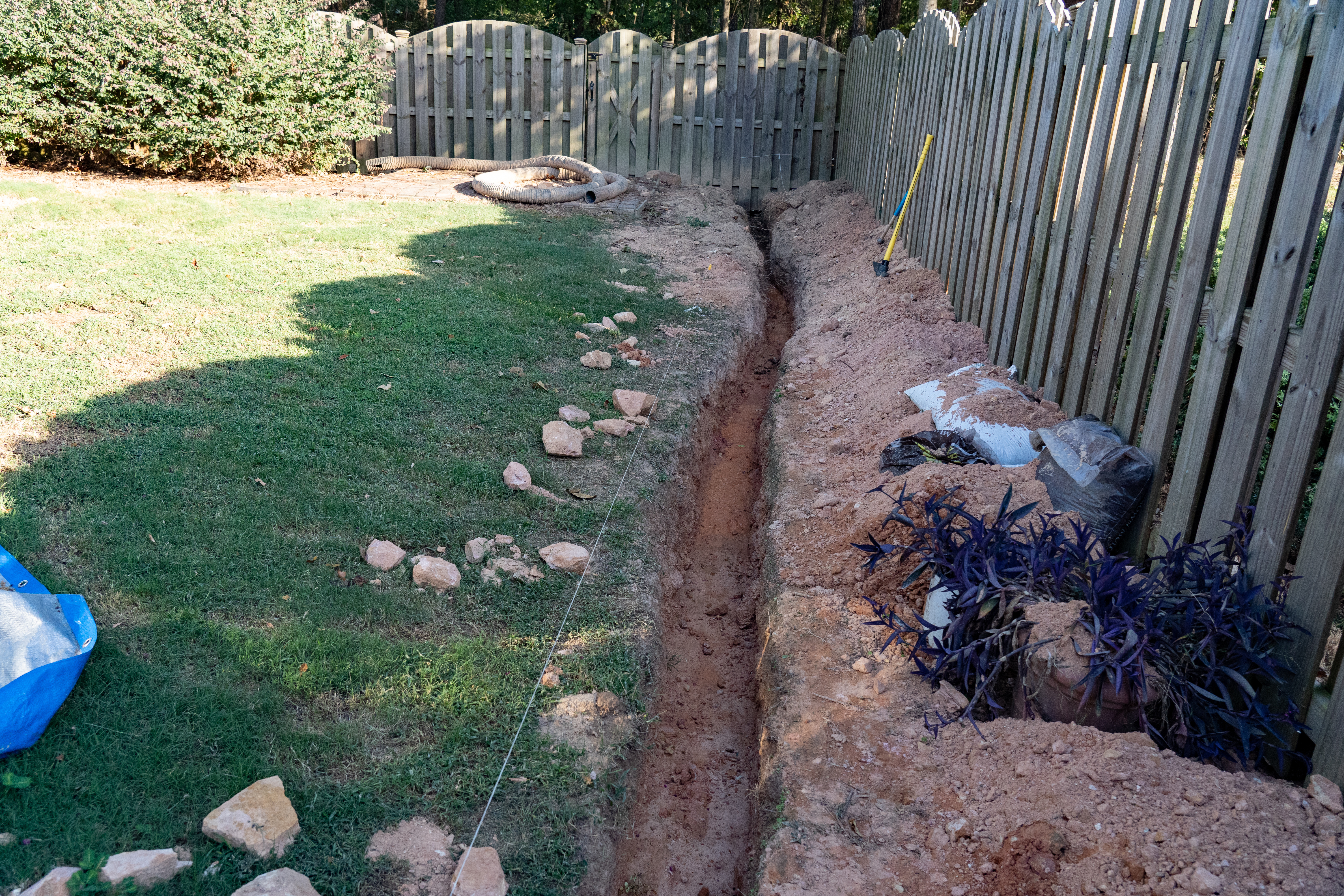 A trench is dug as the first step of a DIY French drain home imp